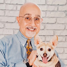 Dr. James Frazier holding a small cute dog